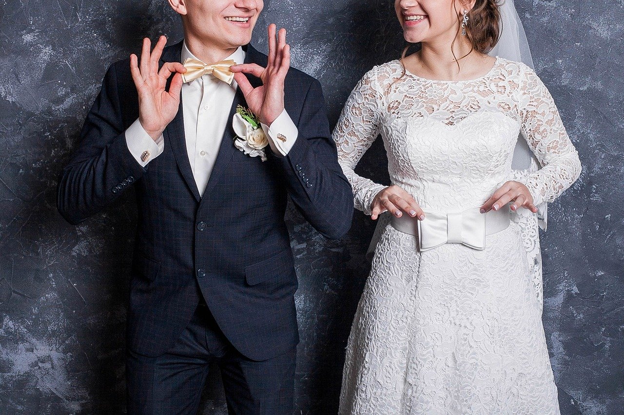 Hochzeitspaar, Mann mit Anzug und Fliege, Frau im weißen Brautkleid, Gesicht nicht vollständig zu sehen