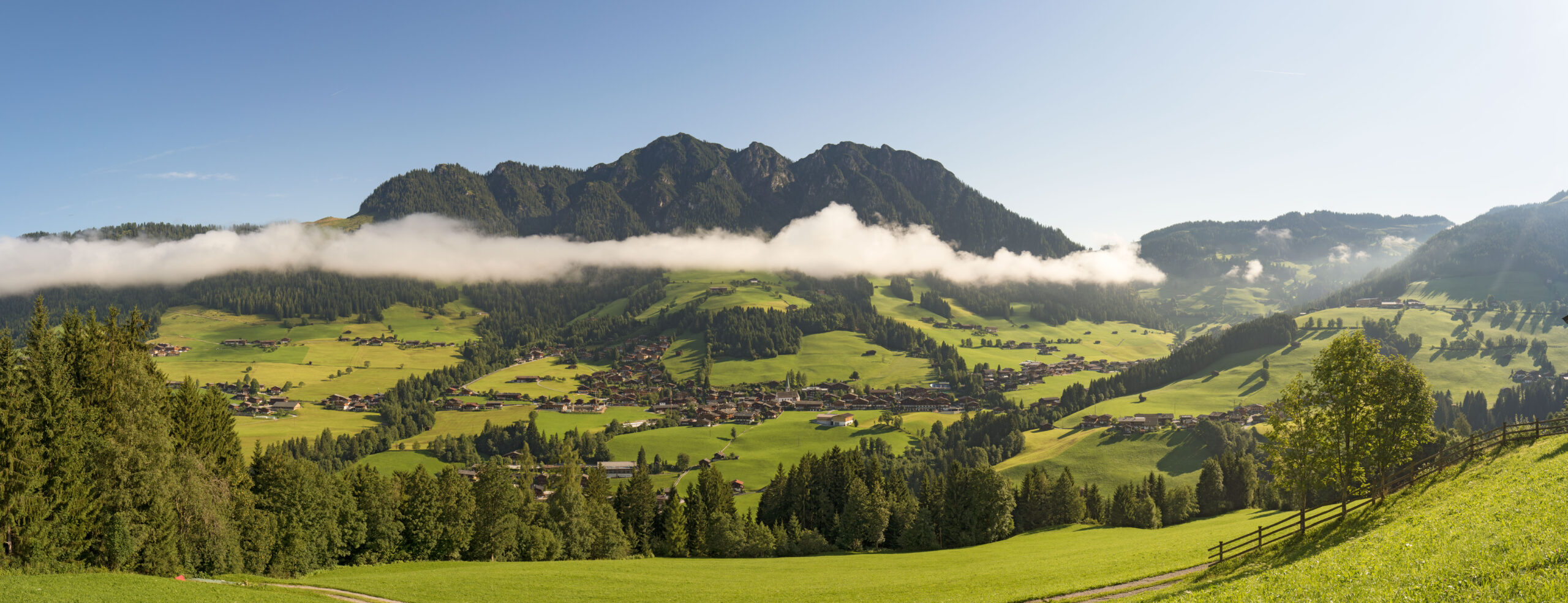 Dorf Alpbach eingebetten in grüne Wiesen, Berge im Hintergrund