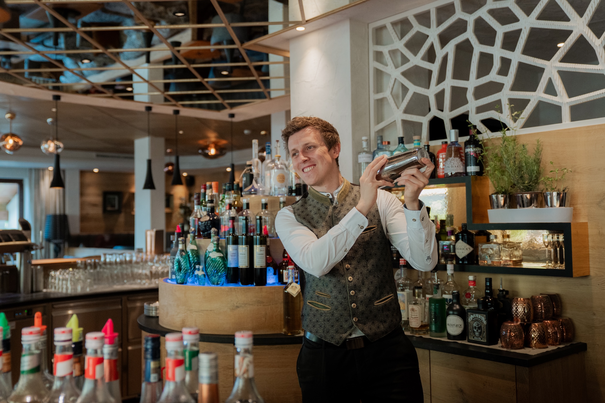 Barkeeper im Hotel Alpbacherhof mixt einen Cocktail an der stilvollen Bar