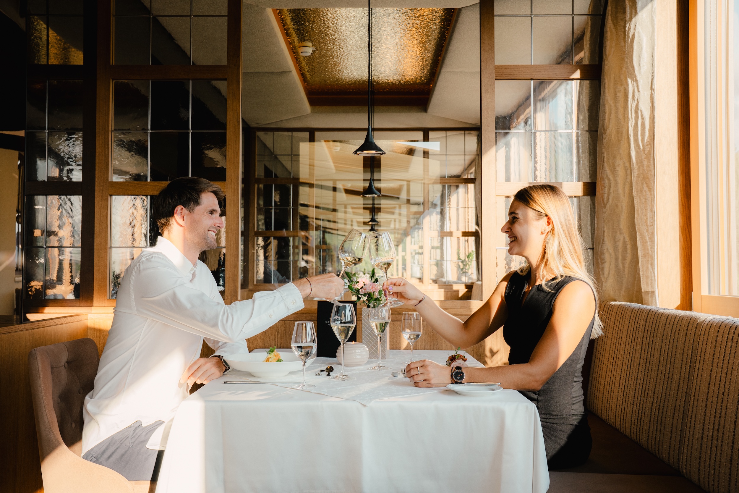 Junges Paar genießt das 6-Gang-Abendmenü mit Weinbegleitung im Panoramarestaurant des Hotel Alpbacherhof in Tirol