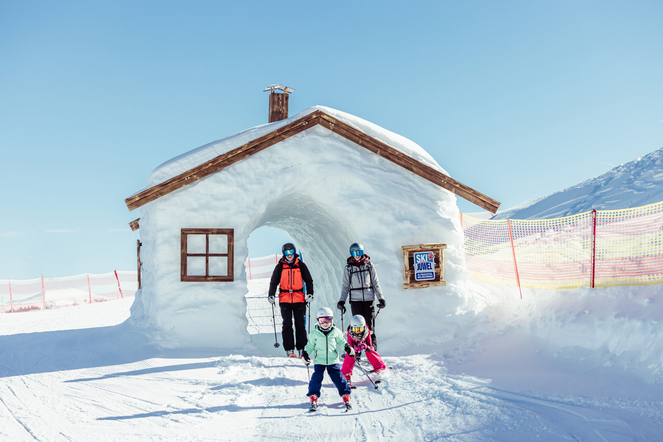Familie beim Skifahren, durch Schneehaus durchfahrend