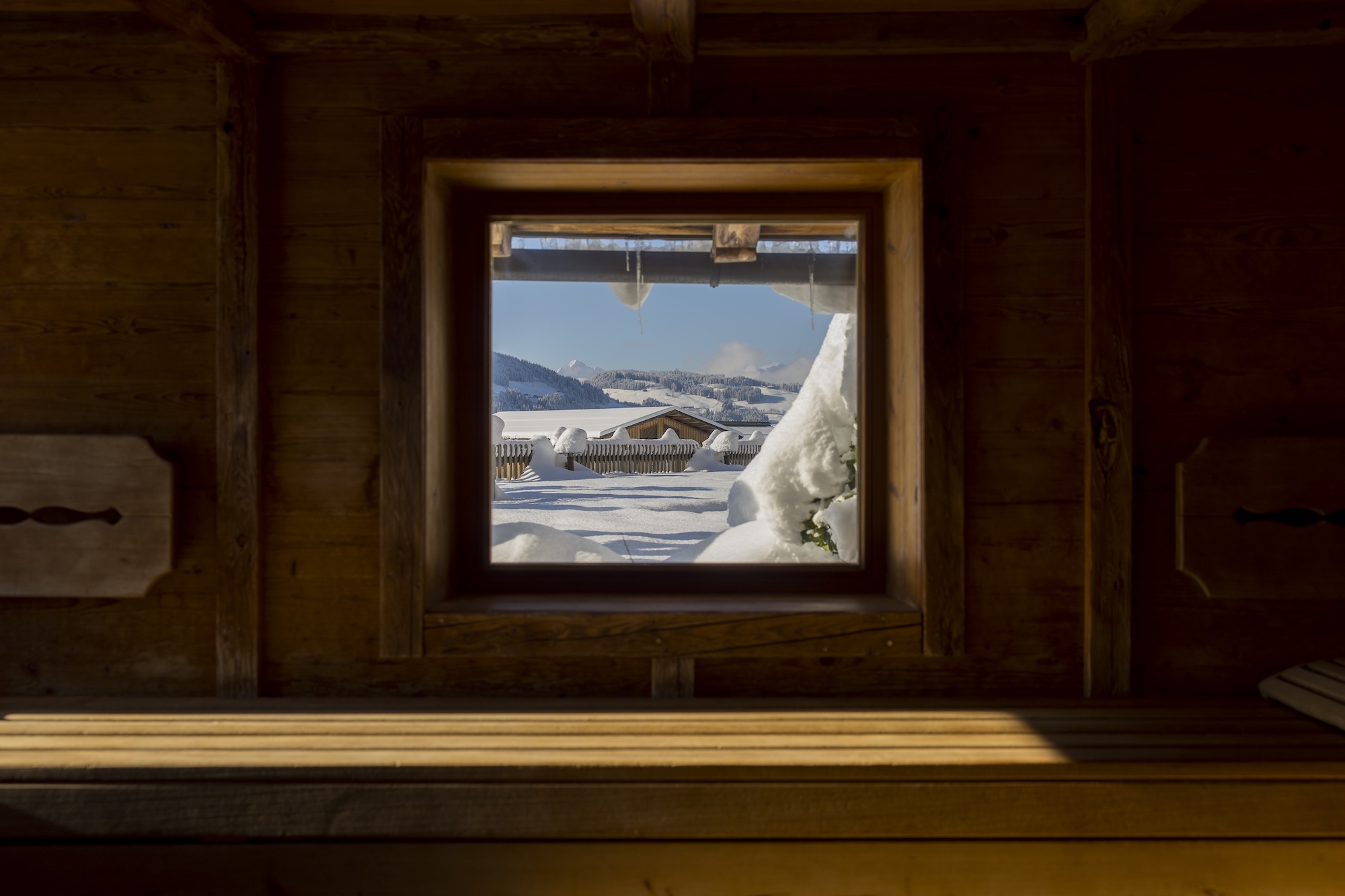 Panoramasauna Wellnesshotel Alpbacherhof mit Blick ins verschneite Tal
