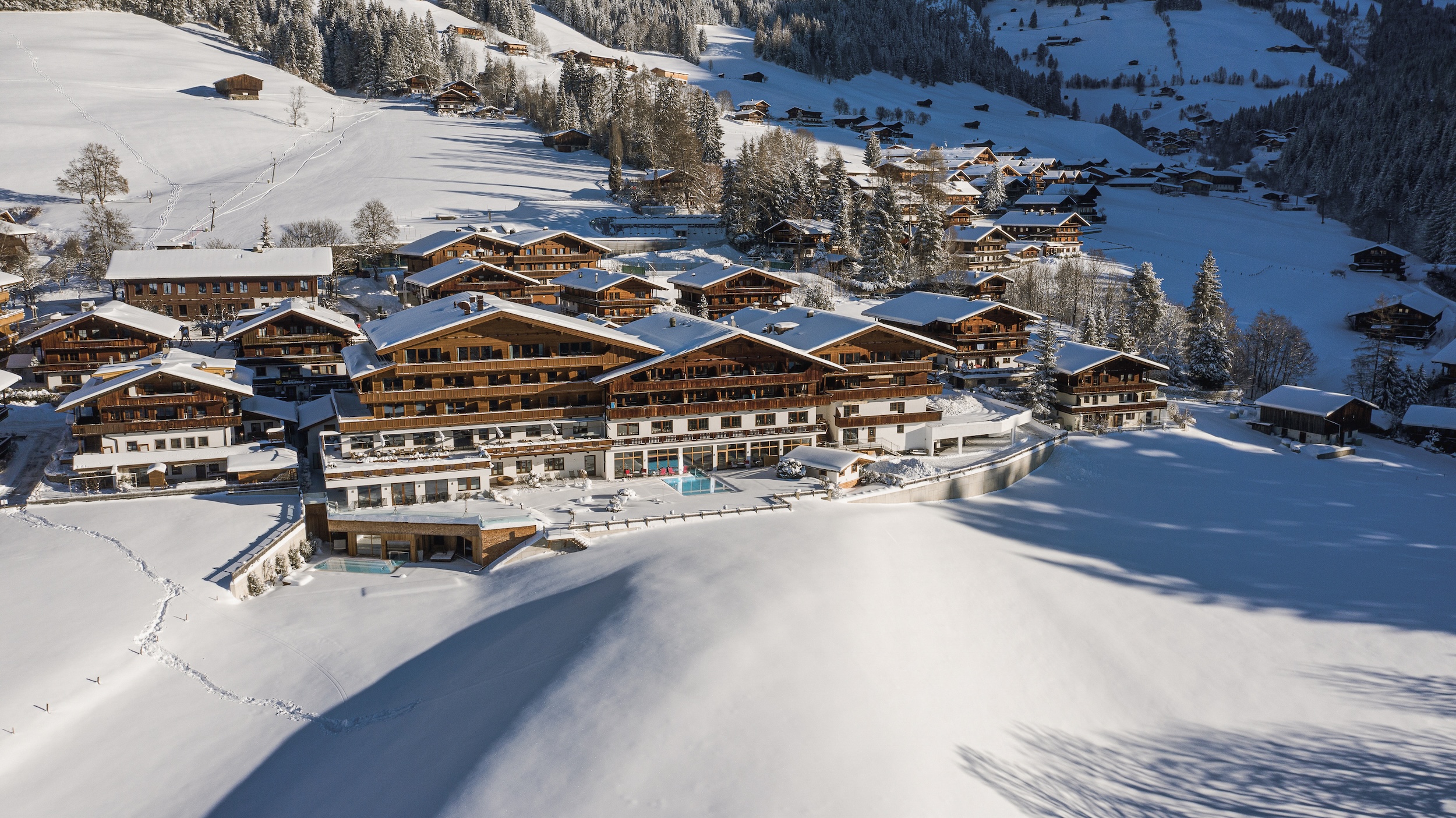 Wellnesshotel Hotel Alpbacherhof in Tirol in Schneelandschaft mit Panoramablick und Außenpool