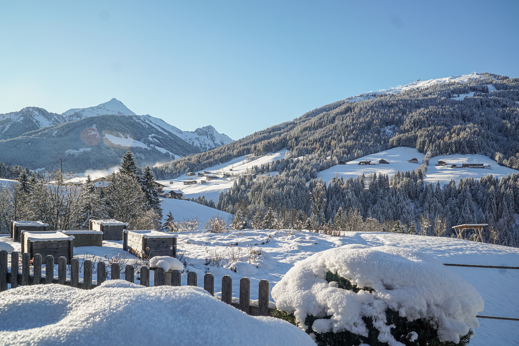 Tief verschneiter Garten und Ausblick auf winterliche Berglandschaft im Alpbachtal