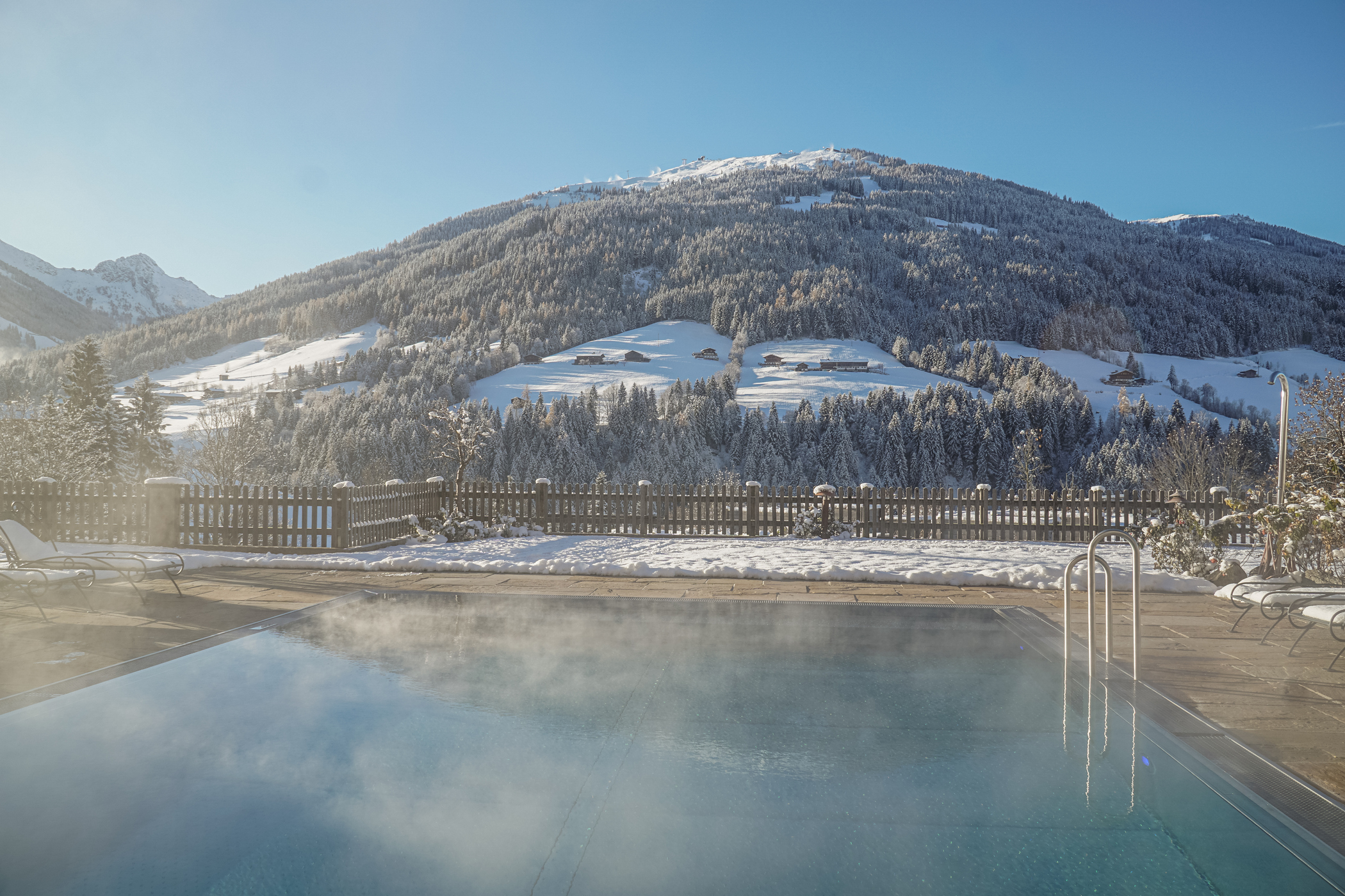 Außenpool im Hotel Alpbacherhof mit Blick auf die verschneite Bergwelt des Alpbachtals