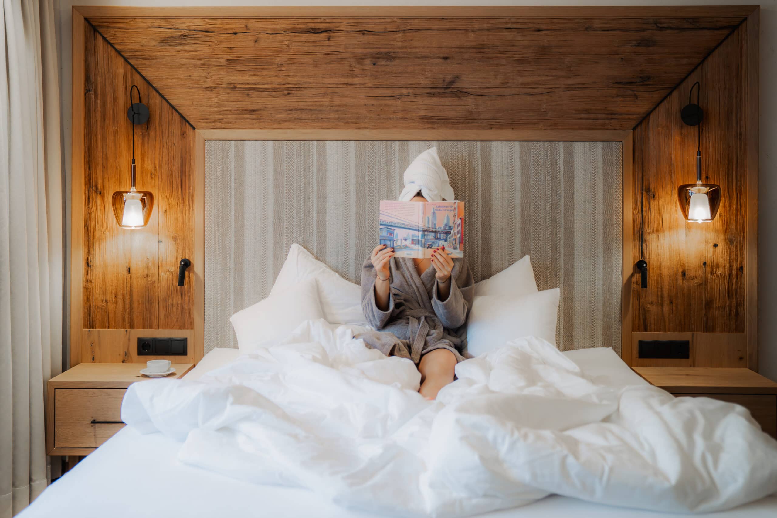 Frau liest Buch im elegant eingerichteten Zimmer des Hotels Alpbacherhof