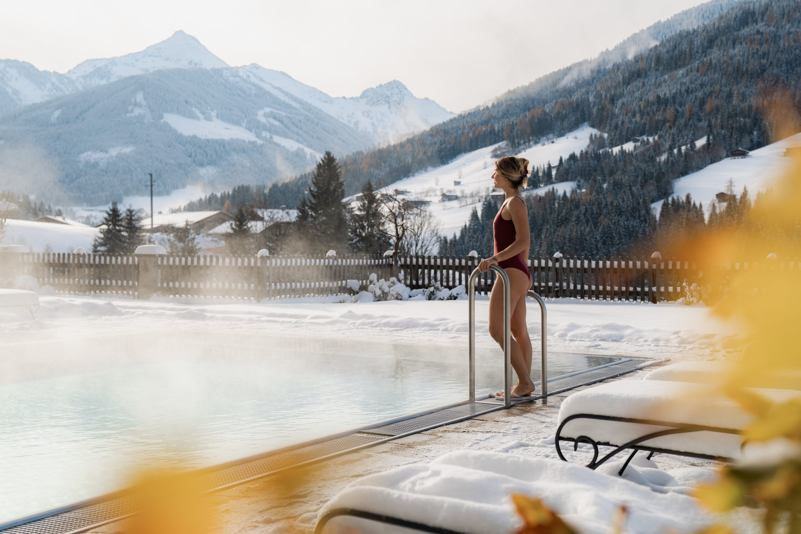 Frau am Outdoorpool im Alpbacherhof mit Blich auf das Alpbachtal