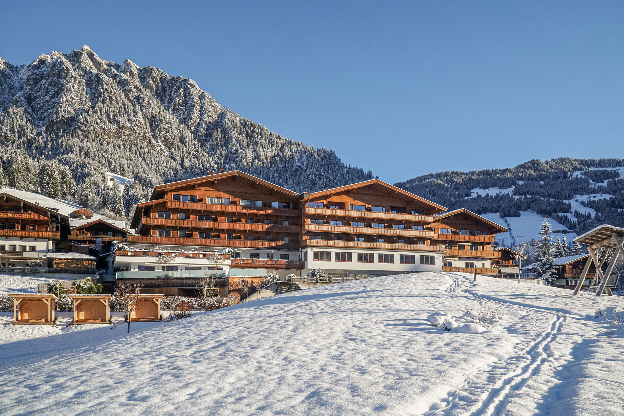 Außenansicht Alpbacherhof im Winter mit Blick zu den verschneiten Bergen im Hintergrund