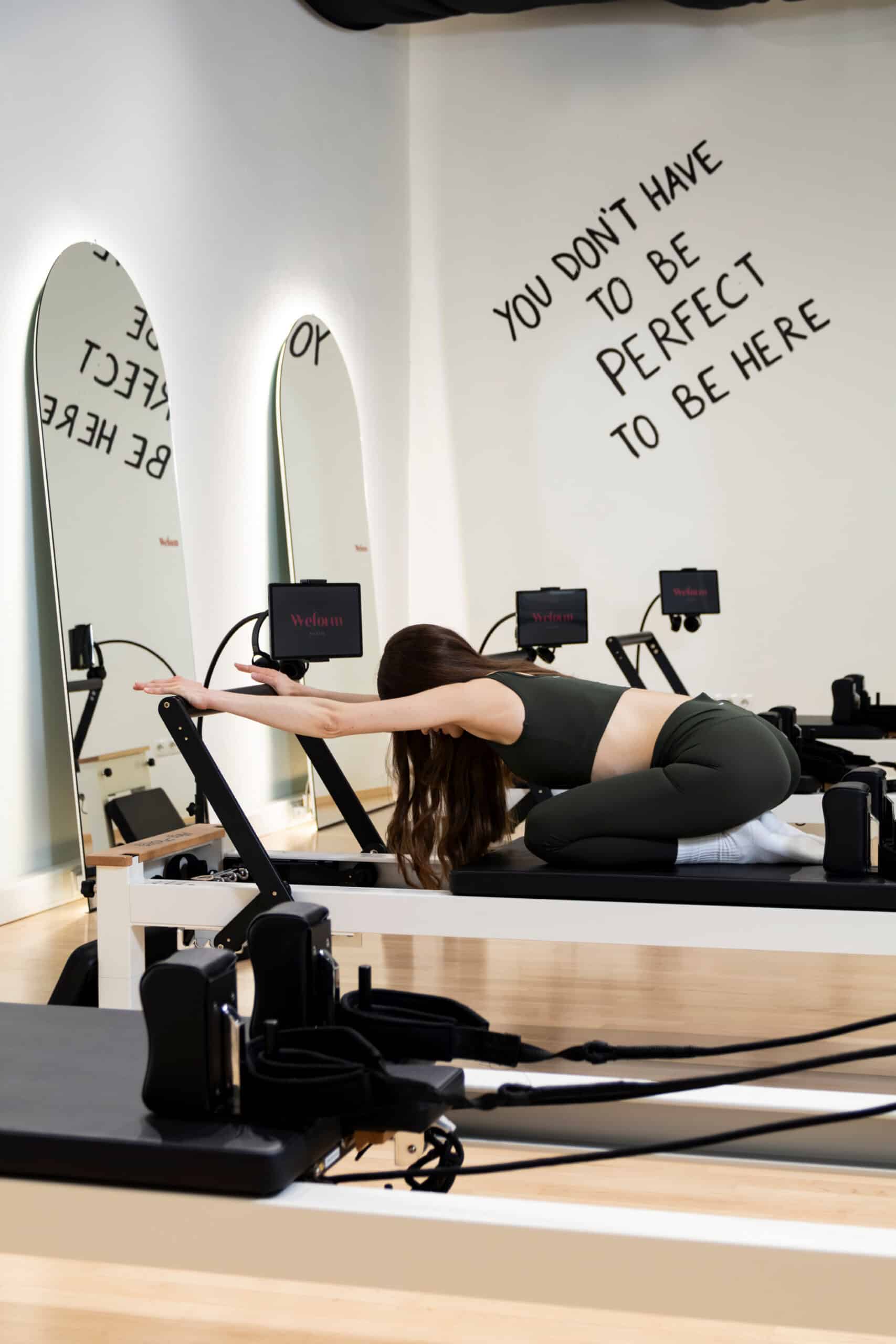 Reformer Pilates Trainerin in ihrem Studio zeigt eine Übung