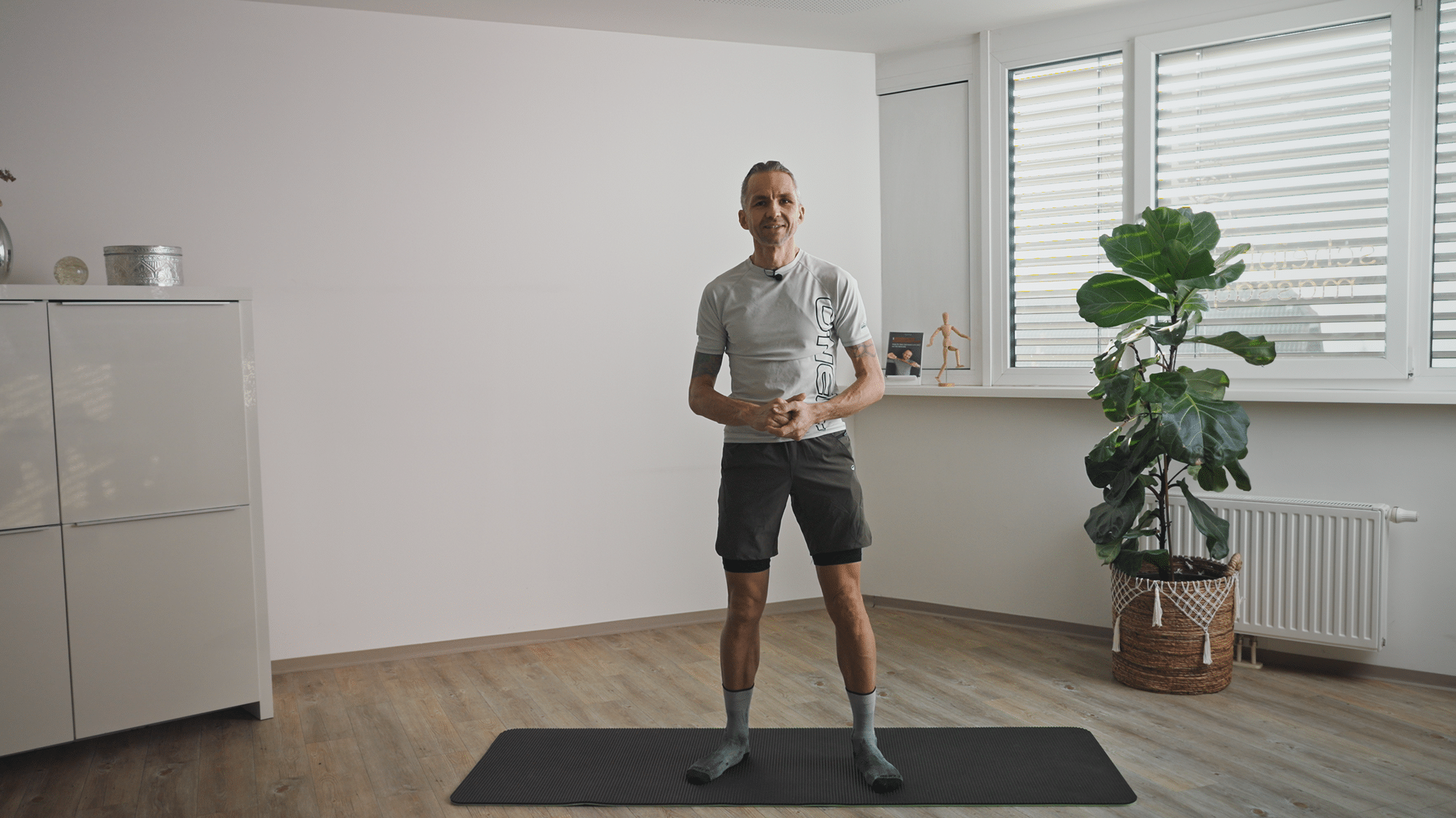 Herbert Scheipl_mit Trainingssachen in seinem Studio_auf Yogamatte